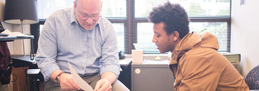 A Student Financial Services employee assists a student with a form | photo by Chris Yang